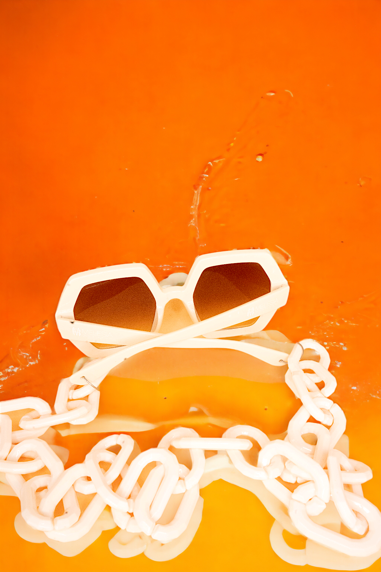 Melesia Robinson's Eyewear's GlamorGon bold chunky chain design statement sunglasses that not only offer fashion but also protect your eyes. These shades are available in Four colors: stylish light beige, chic rust brown, black on black, and black on orange lens.