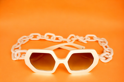 Melesia Robinson's Eyewear's GlamorGon bold chunky chain design statement sunglasses that not only offer fashion but also protect your eyes. These shades are available in Four colors: stylish light beige, chic rust brown, black on black, and black on orange lens.