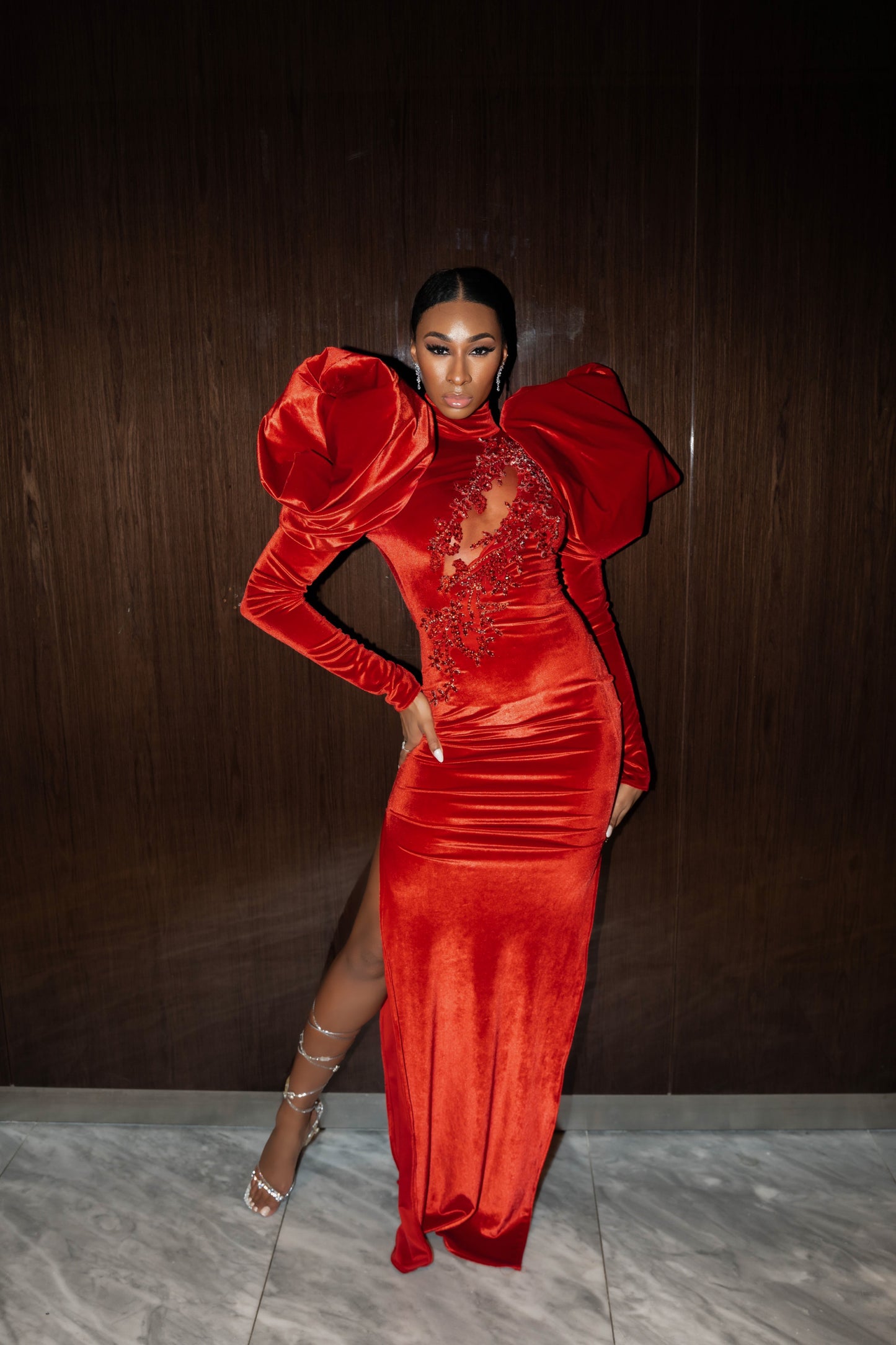Red velvet dress features  puff shoulders, embellishment and a zipper closure.